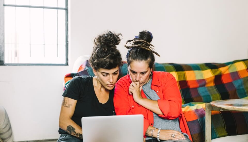 two women using a laptop to do ecommerce search engine optimization for h1 tags.