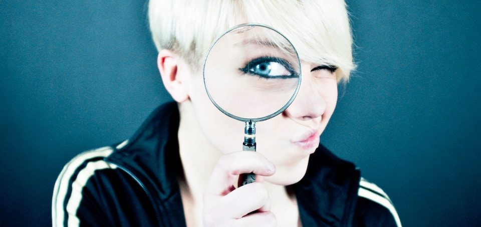woman with magnifying glass researching keywords for her seo strategy