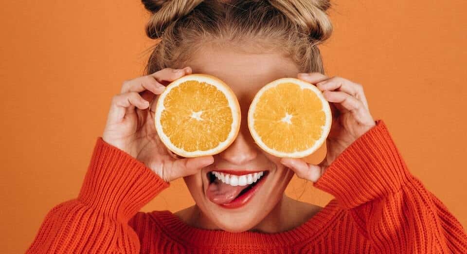 woman holding orange slices in front of her eyes to represent audience segmentation