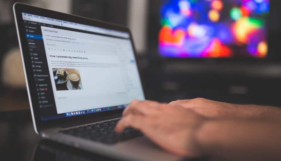 man writing a blog on a laptop to build brand awareness through thought leadership