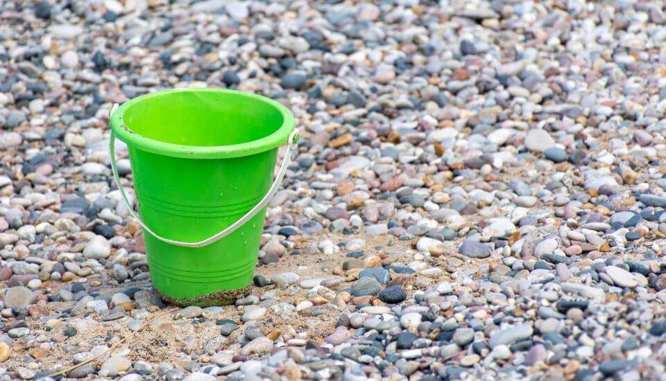 green bucket on stones catching drops of water to illustrate capturing more website conversions