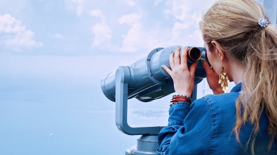 woman searching the ocean with binoculars to represent b2b seo