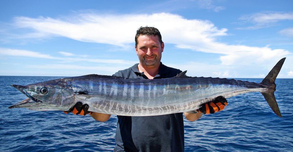 Man holding large fish he acquired for a customer