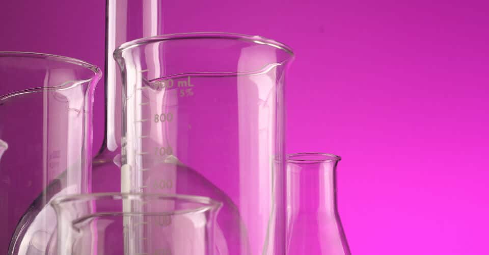 measuring flasks on purple background