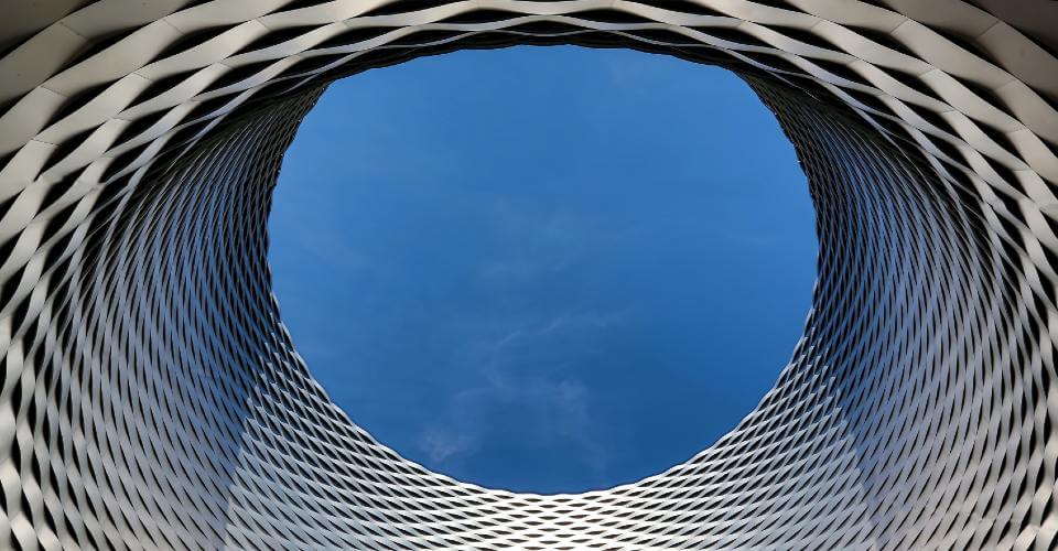 circular blue sky seen through a gray steel cylinder