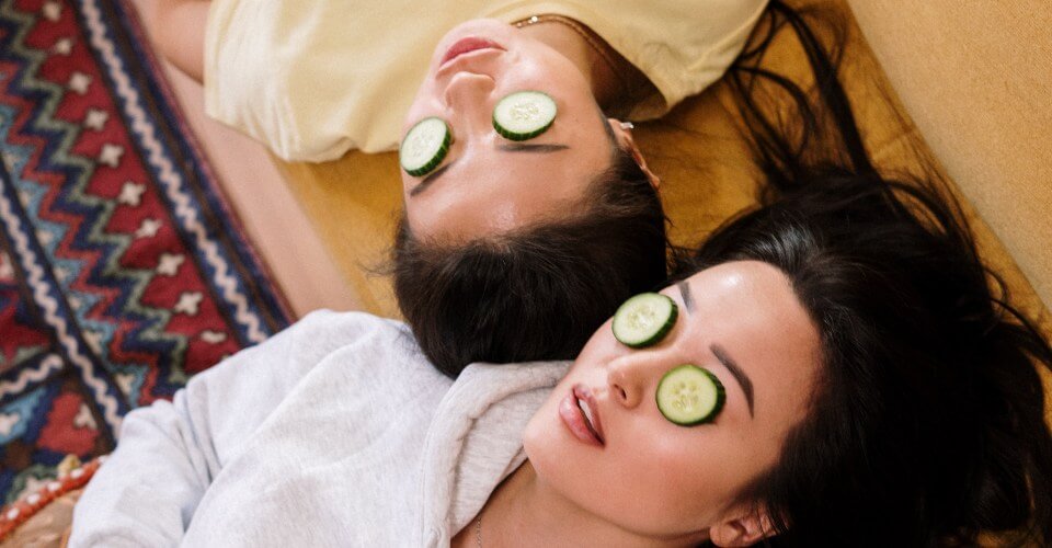 women with cucumbers on their eyes