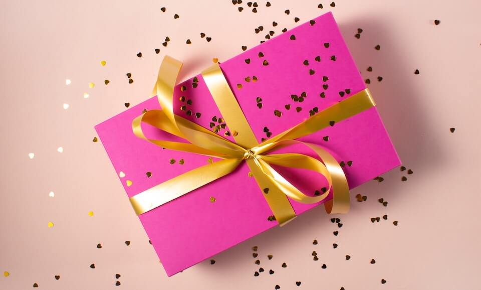 pink gift with gold ribbon to build customer loyalty and improve retention