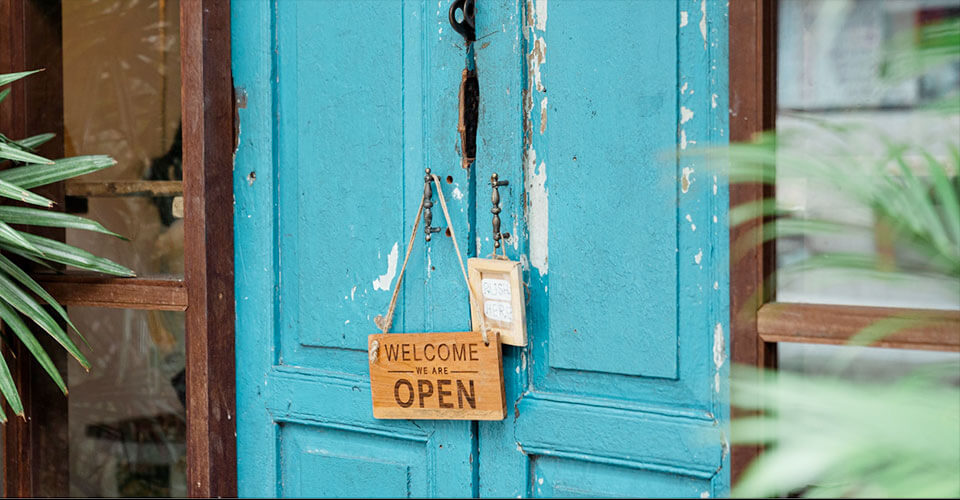 open for business sign on a blue wooden door