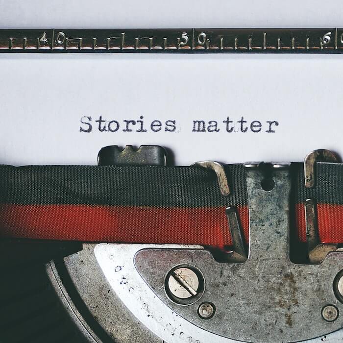close up of a typewriter with text that reads stories matter
