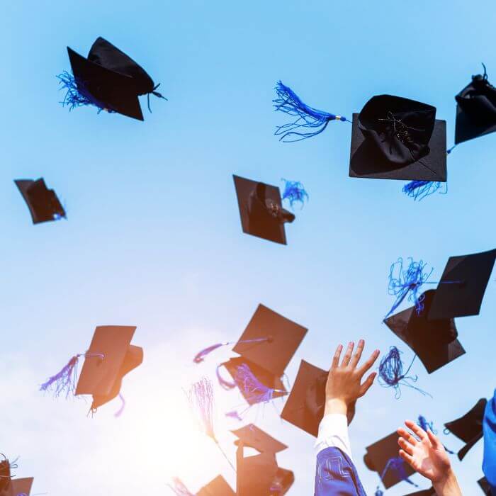 Graduation caps thrown in the air.