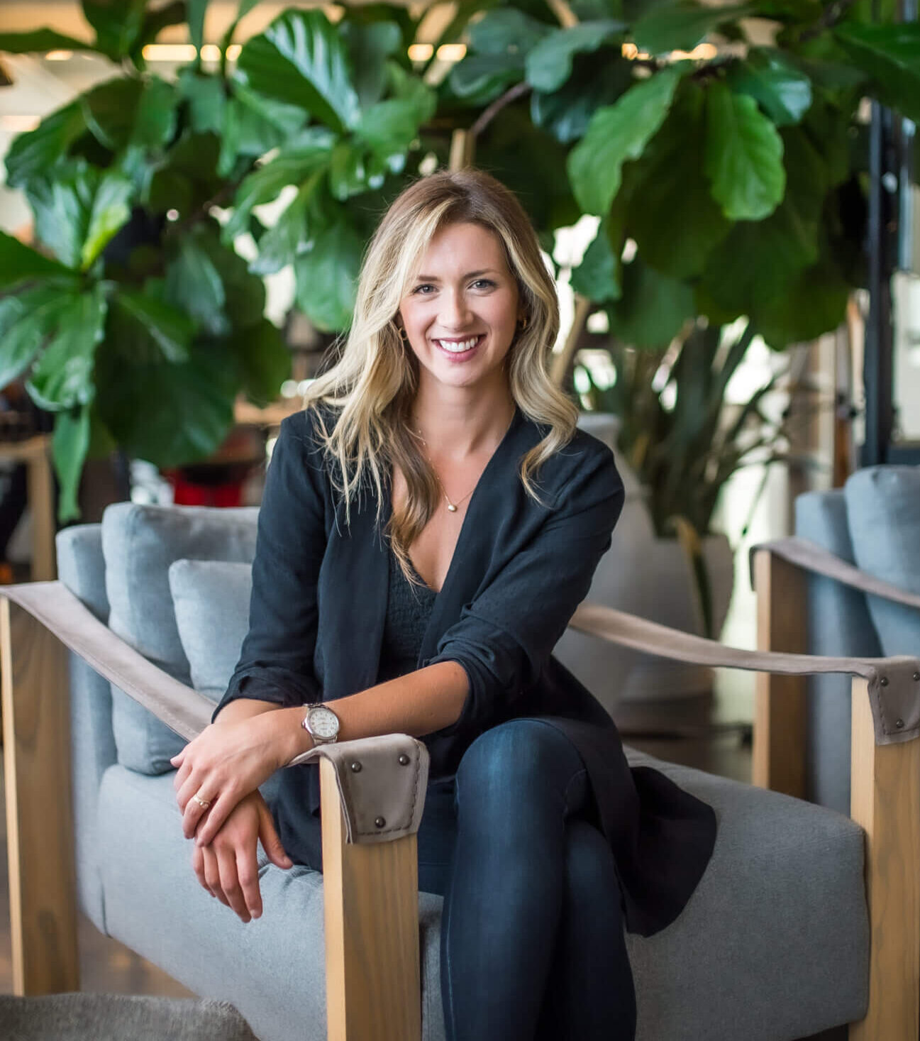 Blonde woman sits and smiles at the camera