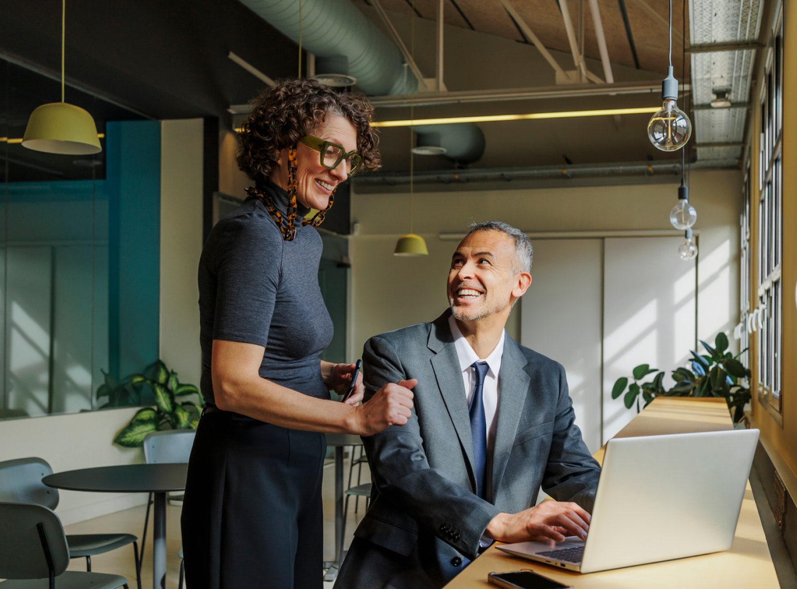Woman and man smiling, looking at computer
