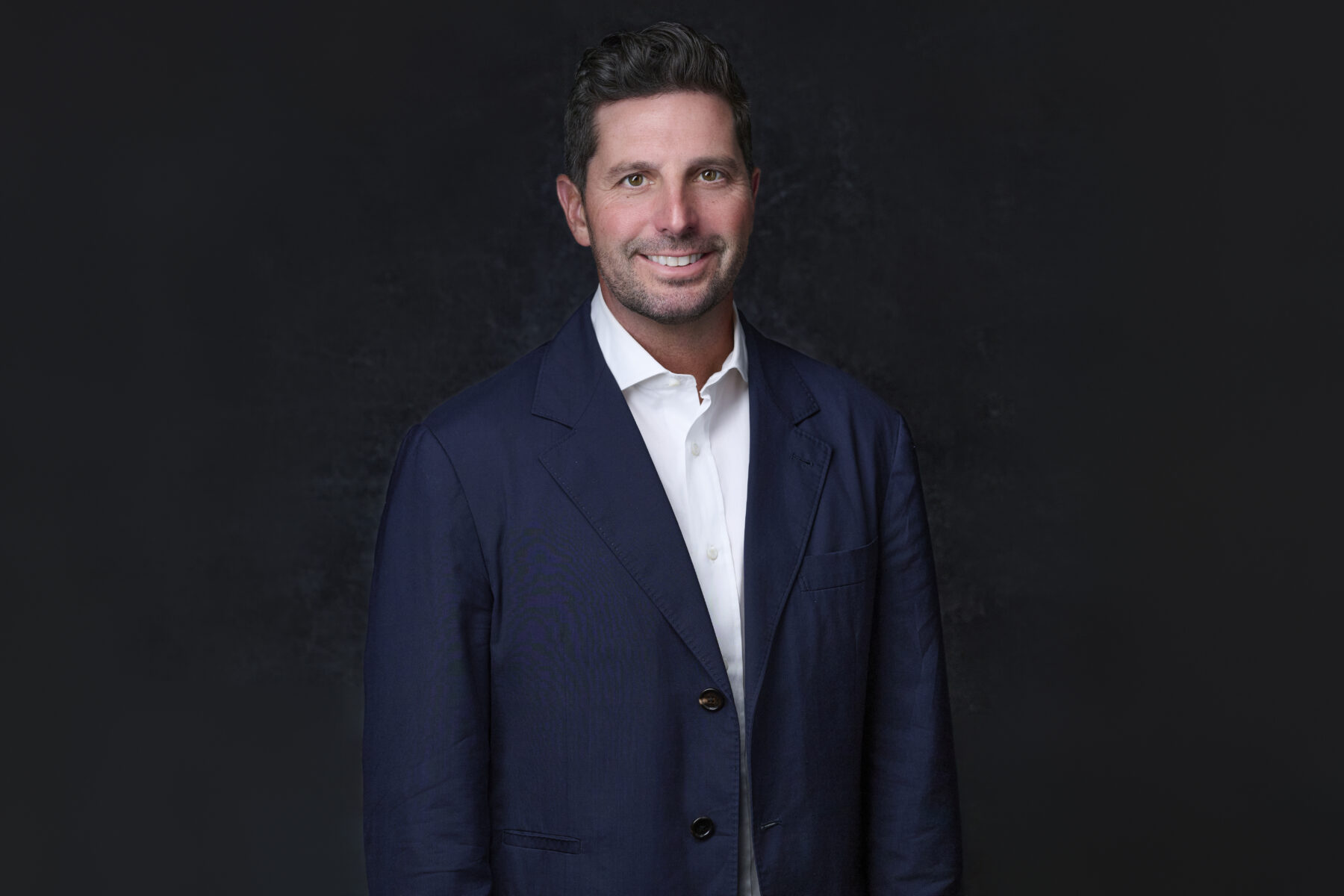 MacLaren "Mac" Cummings smiles in a blue suit