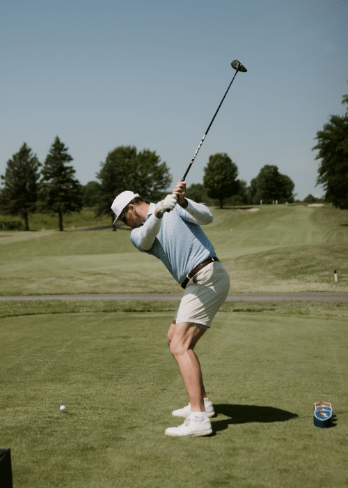 A man swings a golf club
